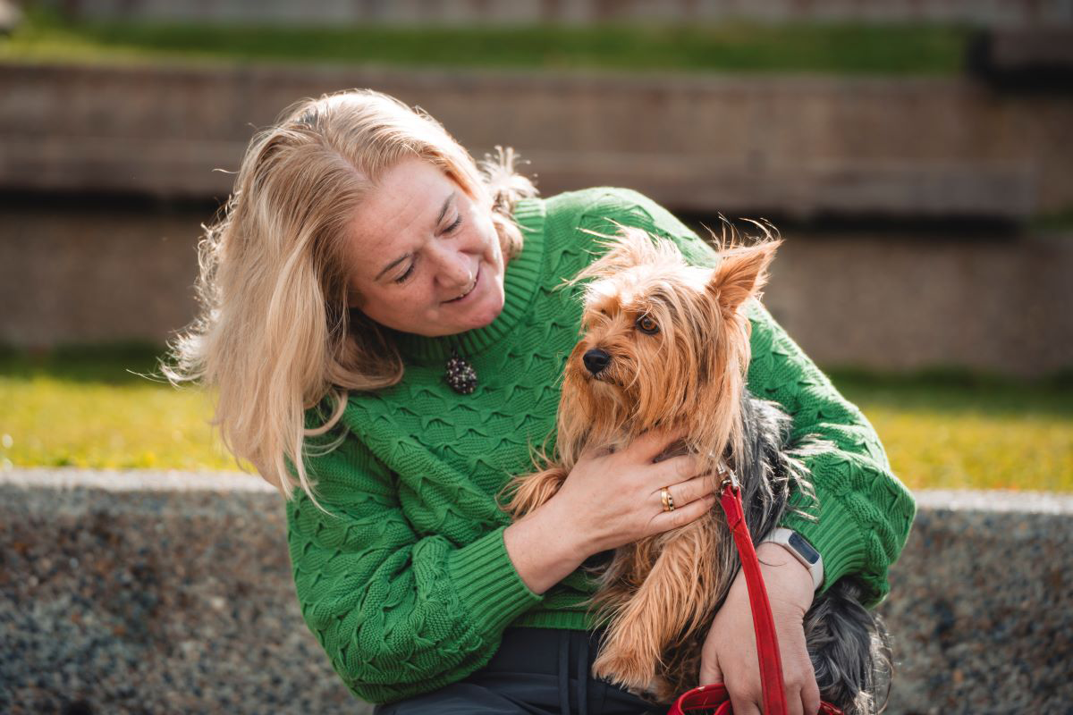 Femme câlinant et embrassant un chien épagneul doré.